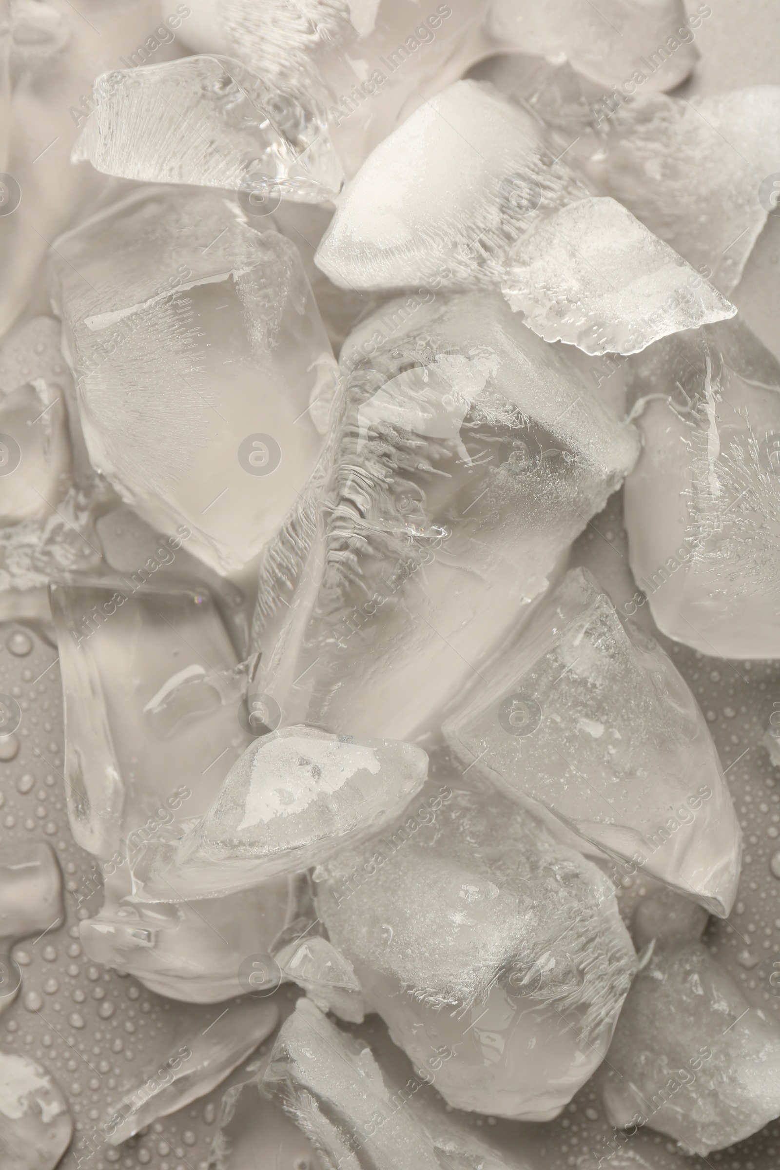 Photo of Pieces of crushed ice on grey background, top view