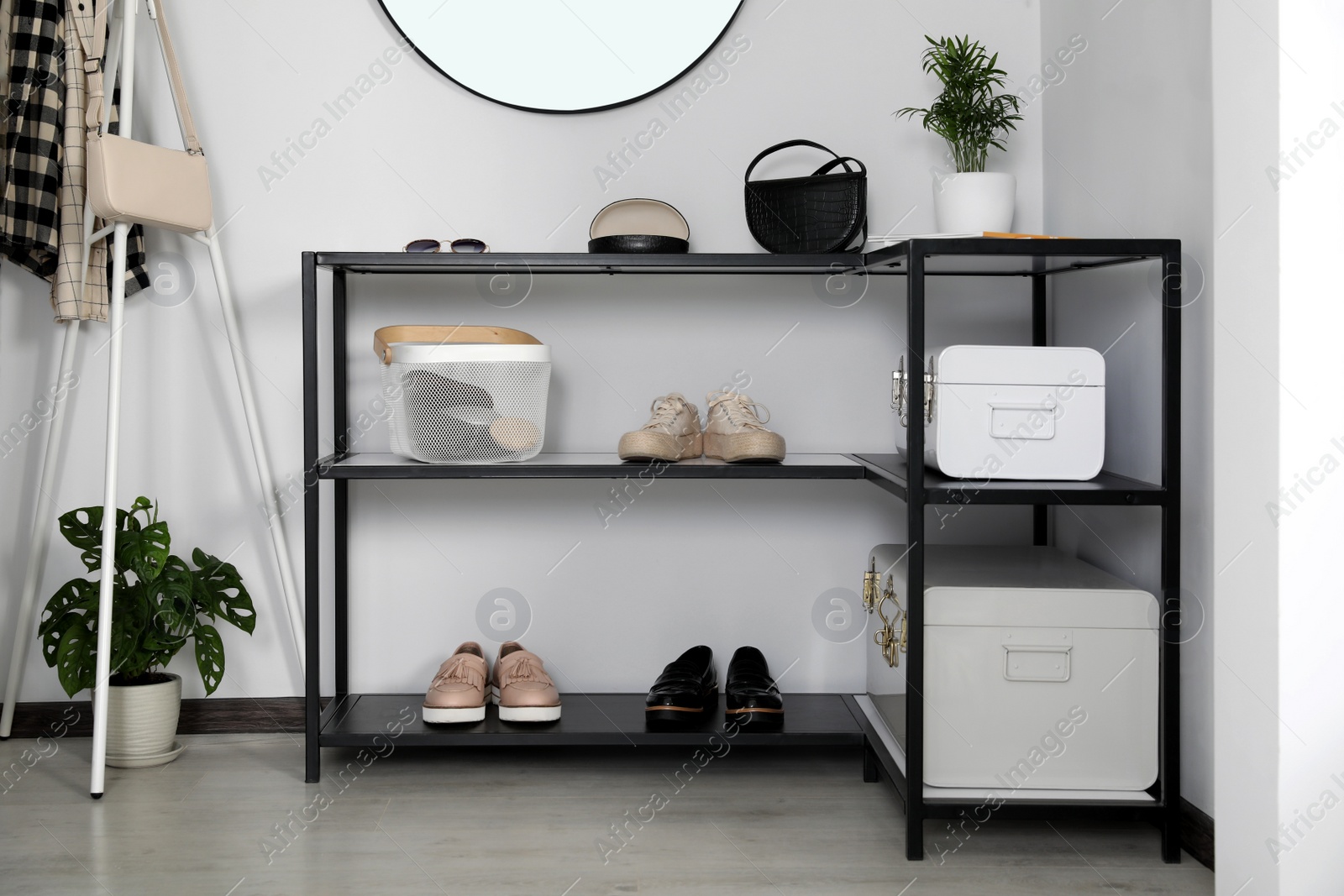 Photo of Black table with stylish shoes and accessories in hallway