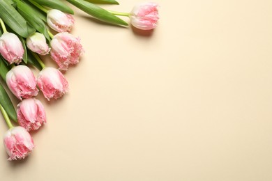 Photo of Beautiful colorful tulip flowers on beige background, top view. Space for text