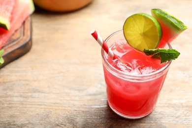 Photo of Delicious fresh watermelon drink on wooden table. Space for text