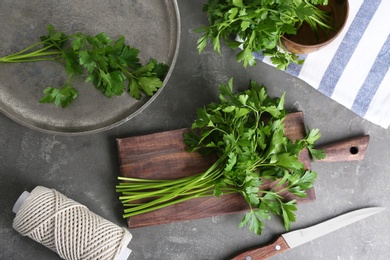 Flat lay composition with fresh green parsley on grey background