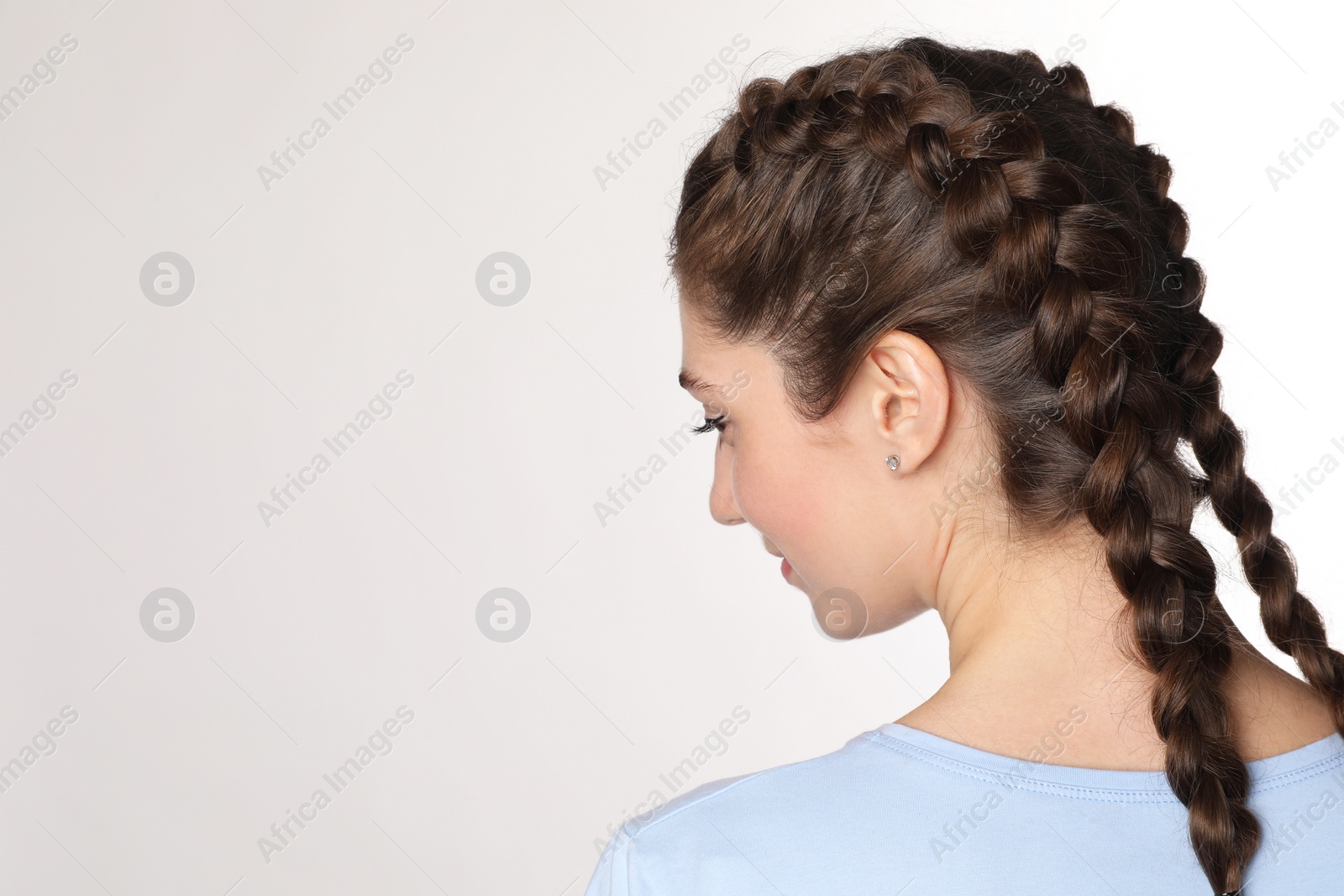 Photo of Woman with braided hair on light background. Space for text