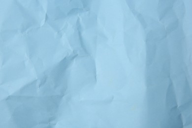 Sheet of crumpled light blue paper as background, top view