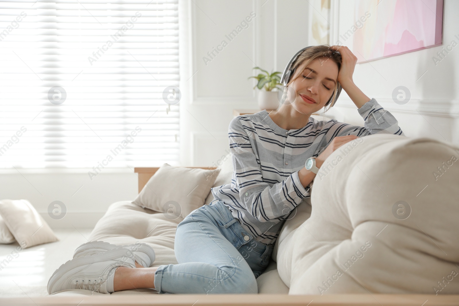 Photo of Young woman listening to music at home