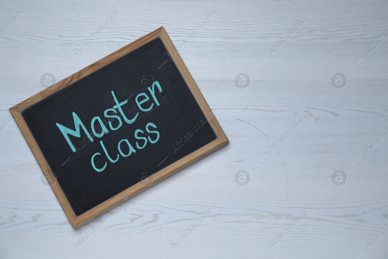 Photo of Blackboard with phrase Master class on white wooden table, top view. Space for text