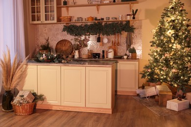 Stylish kitchen with festive decor and Christmas tree. Interior design