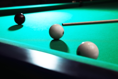 Photo of Balls and cue on modern billiard table