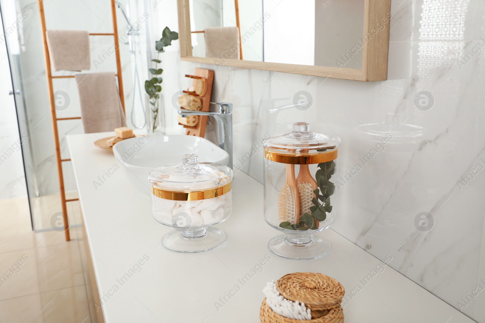 Photo of Jars with cotton pads and hairbrushes on bathroom countertop