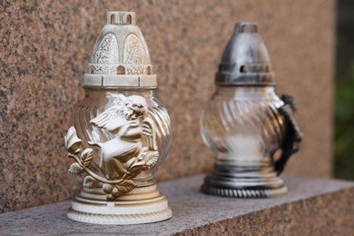 Grave lanterns on granite surface in cemetery