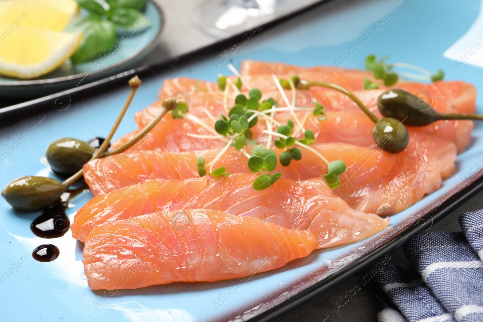 Photo of Delicious salmon carpaccio served on table, closeup