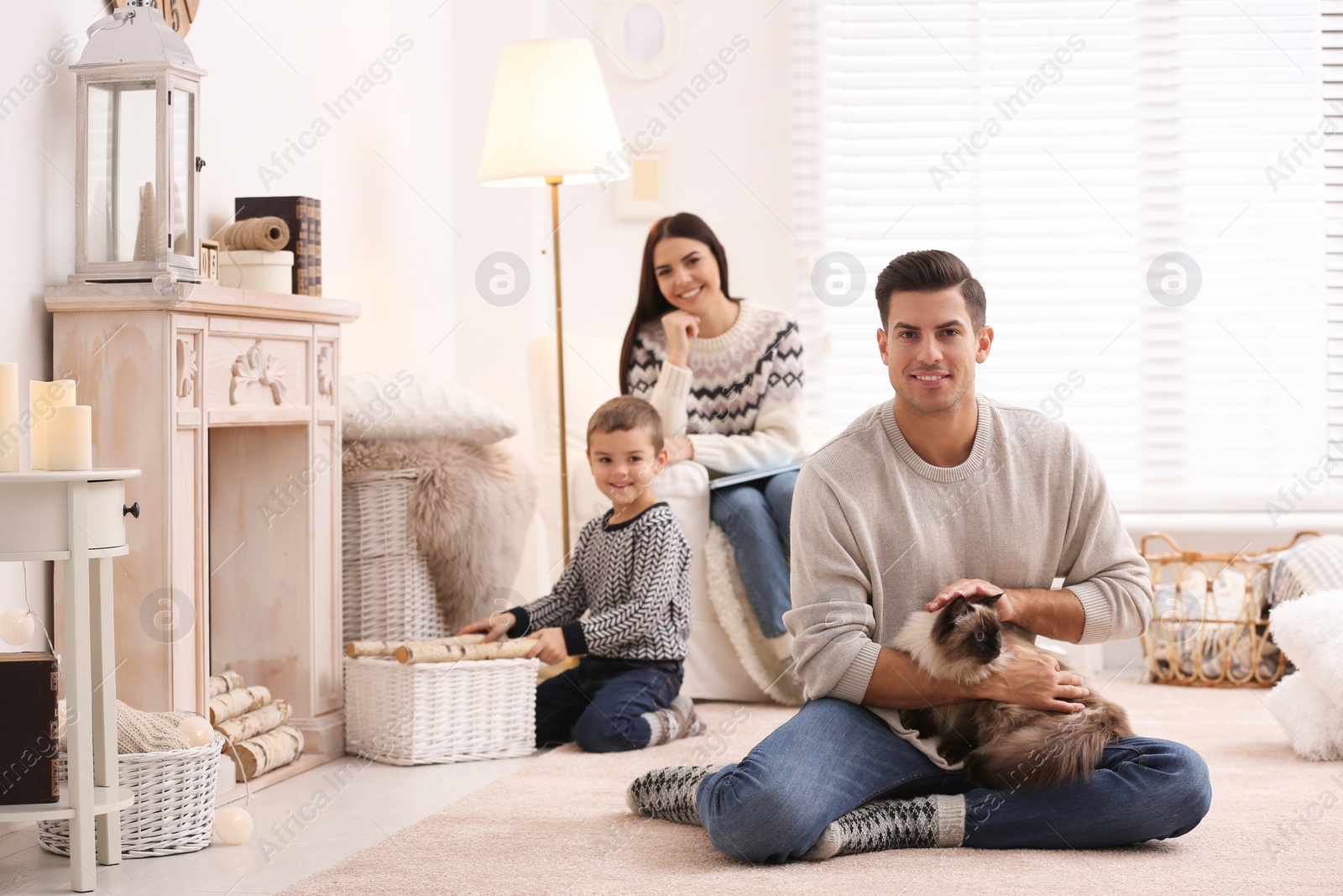 Photo of Father with cat and his family at home. Winter vacation