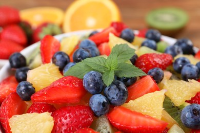 Photo of Delicious fresh fruit salad in bowl on table, closeup