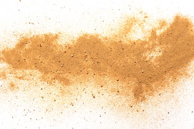 Photo of Pile of brown dust scattered on white background, top view