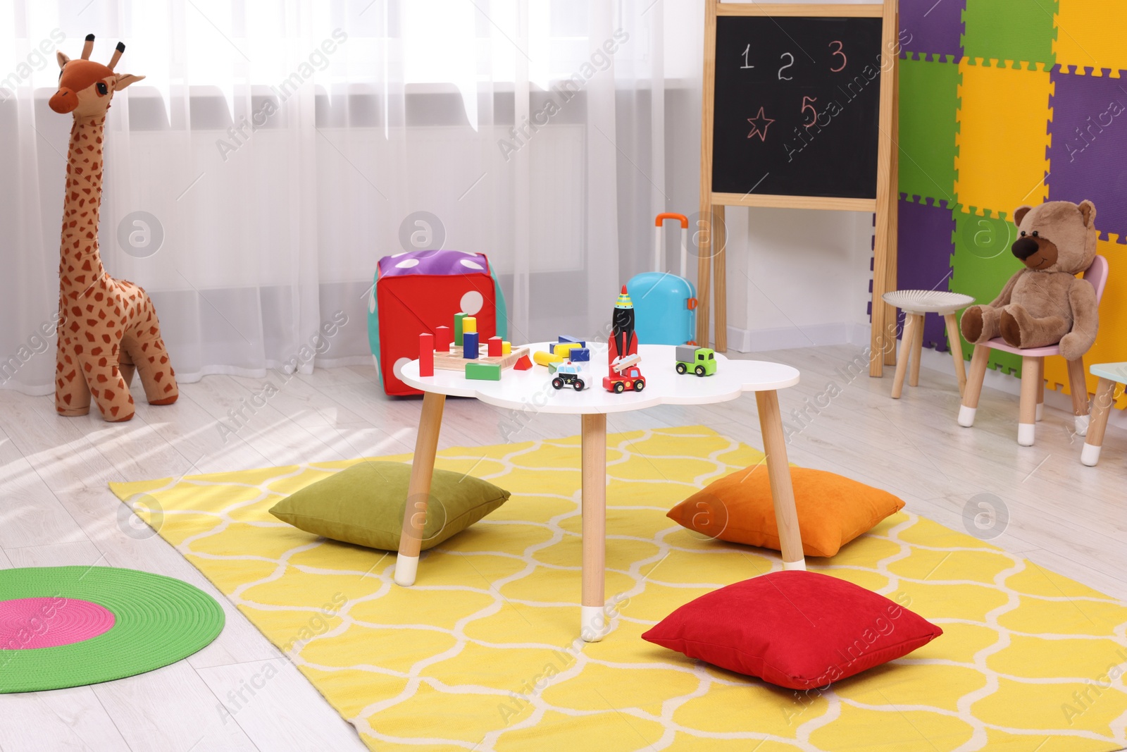 Photo of Child`s playroom with different toys and furniture. Cozy kindergarten interior