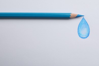 Drawing of water drop and light blue pencil on white background, top view
