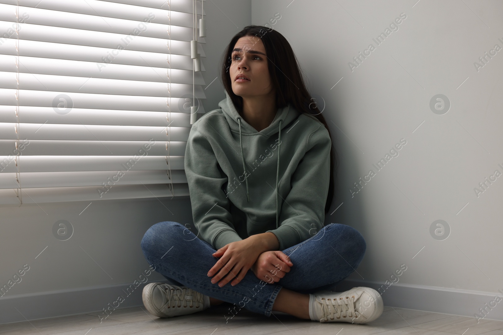 Photo of Sadness. Unhappy woman sitting on floor at home