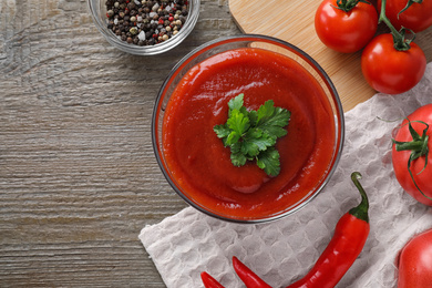 Photo of Flat lay composition with tomato sauce on wooden table