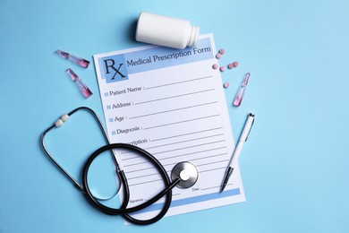 Medical prescription form, stethoscope, ampoules and pills on light blue background