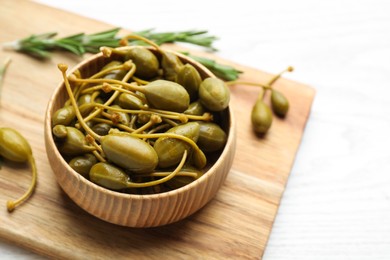 Tasty capers on white wooden table, closeup. Space for text