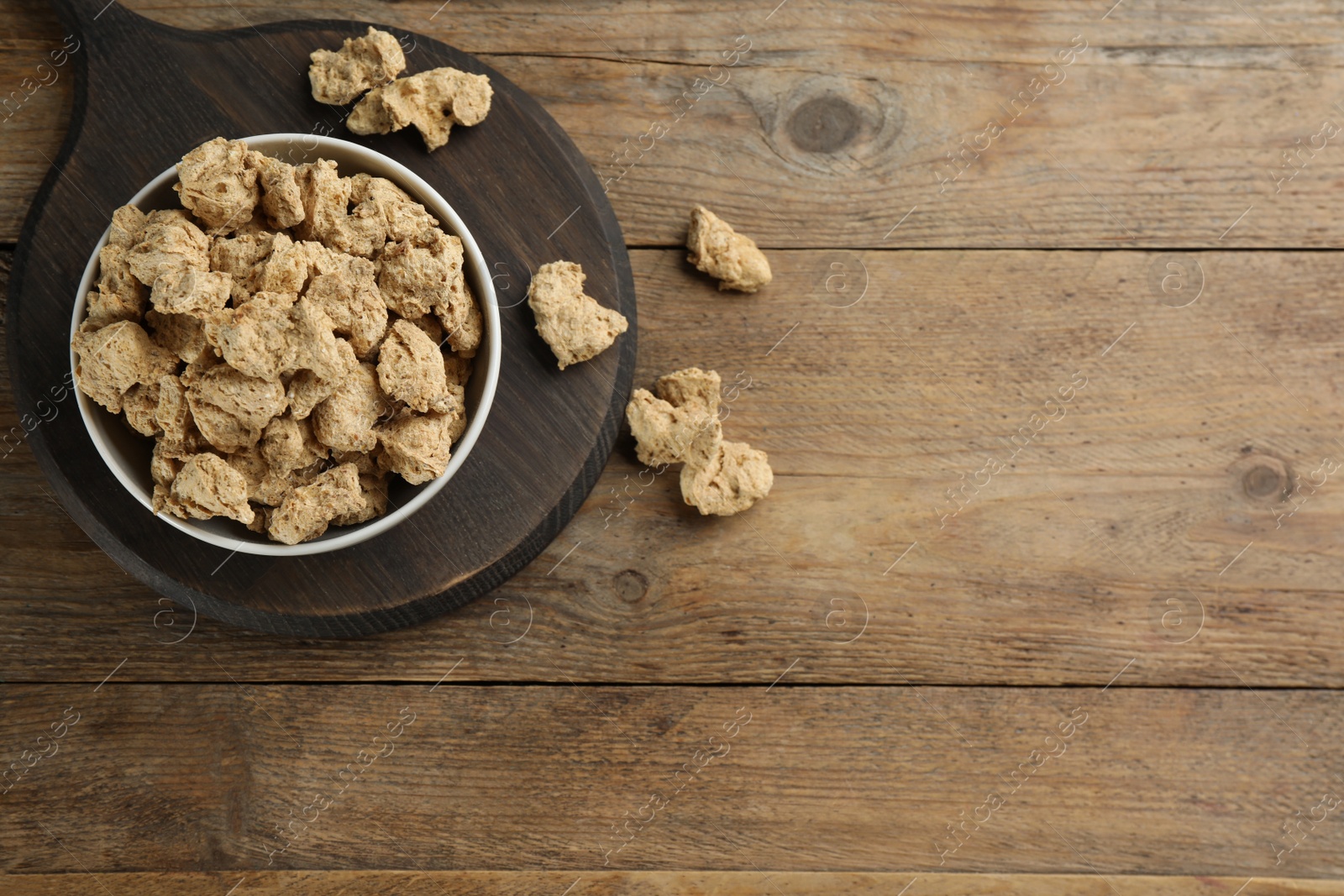 Photo of Dried soy meat on wooden table, flat lay. Space for text