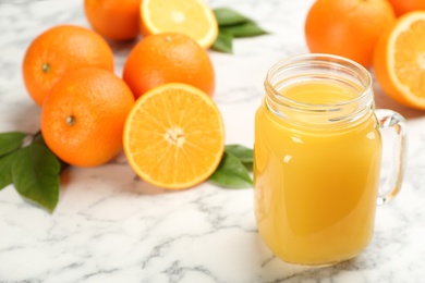 Delicious orange juice and fresh fruits on white marble table, closeup. Space for text