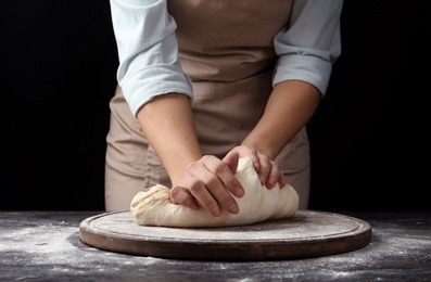 Female baker preparing bread dough at table, closeup