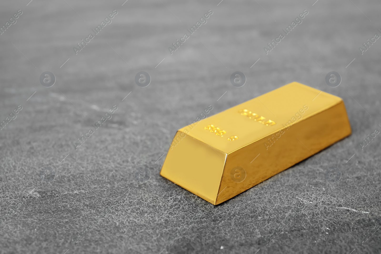 Photo of Shiny gold bar on table. Space for text