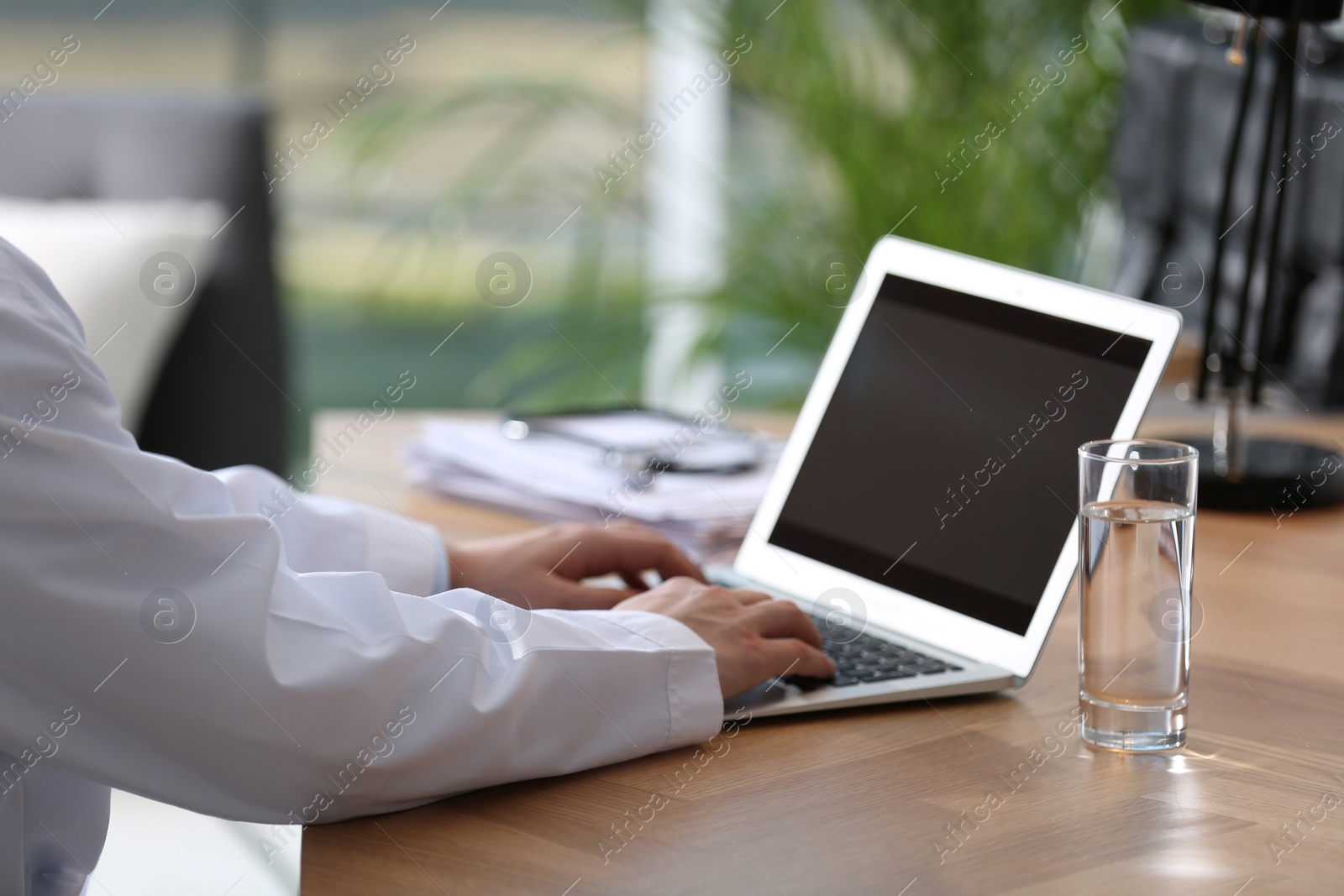 Photo of Professional doctor working on laptop in office, closeup