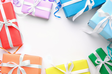 Bright gift boxes on white background, top view. Rainbow colors