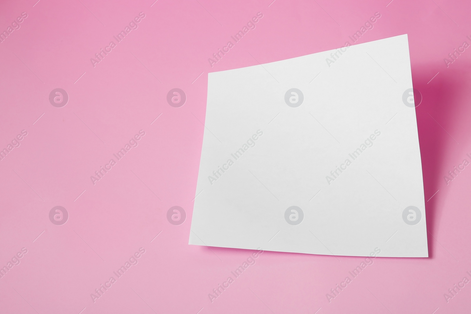 Photo of Empty sheet on pink background. Mockup for design