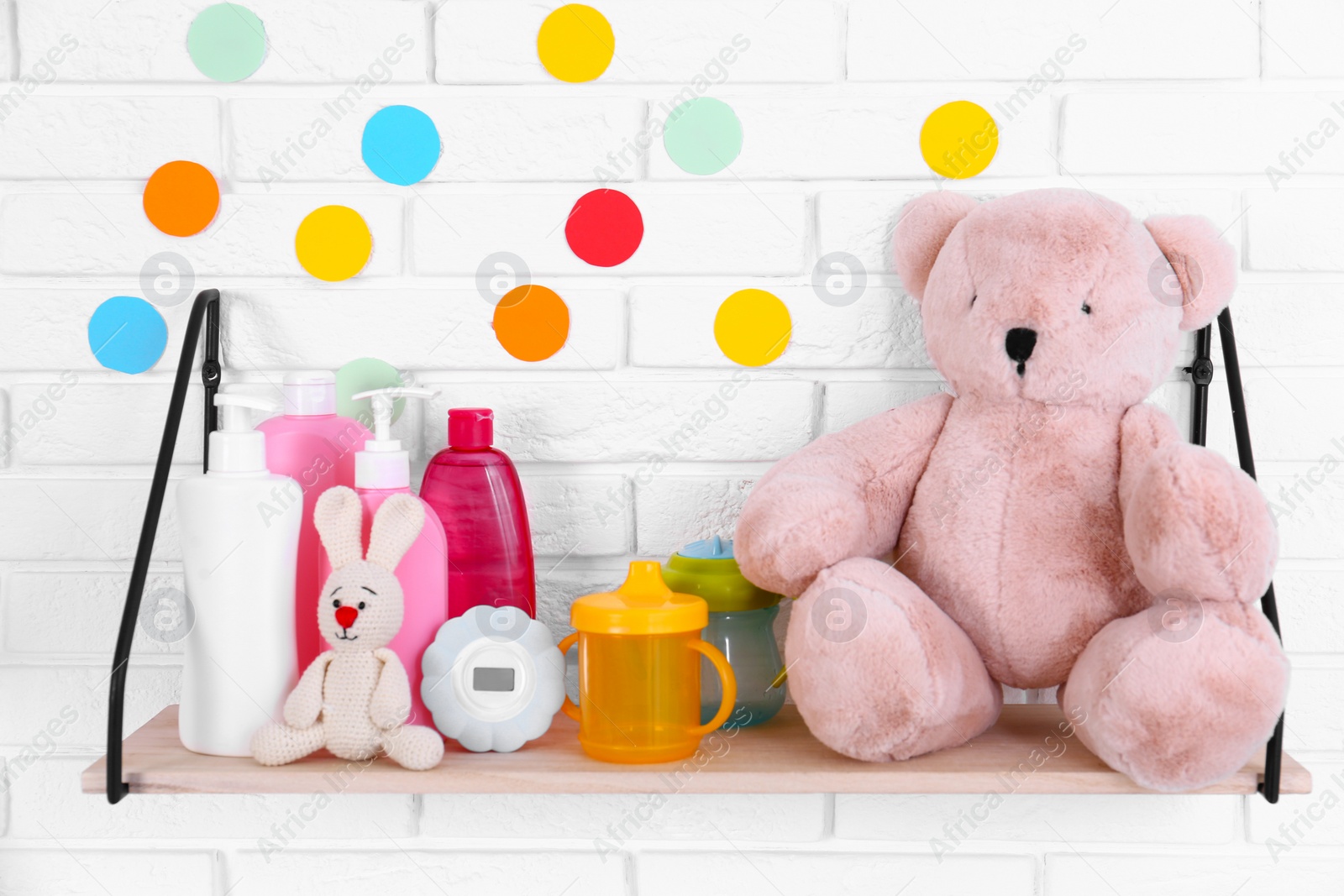 Photo of Baby accessories on shelf near white brick wall