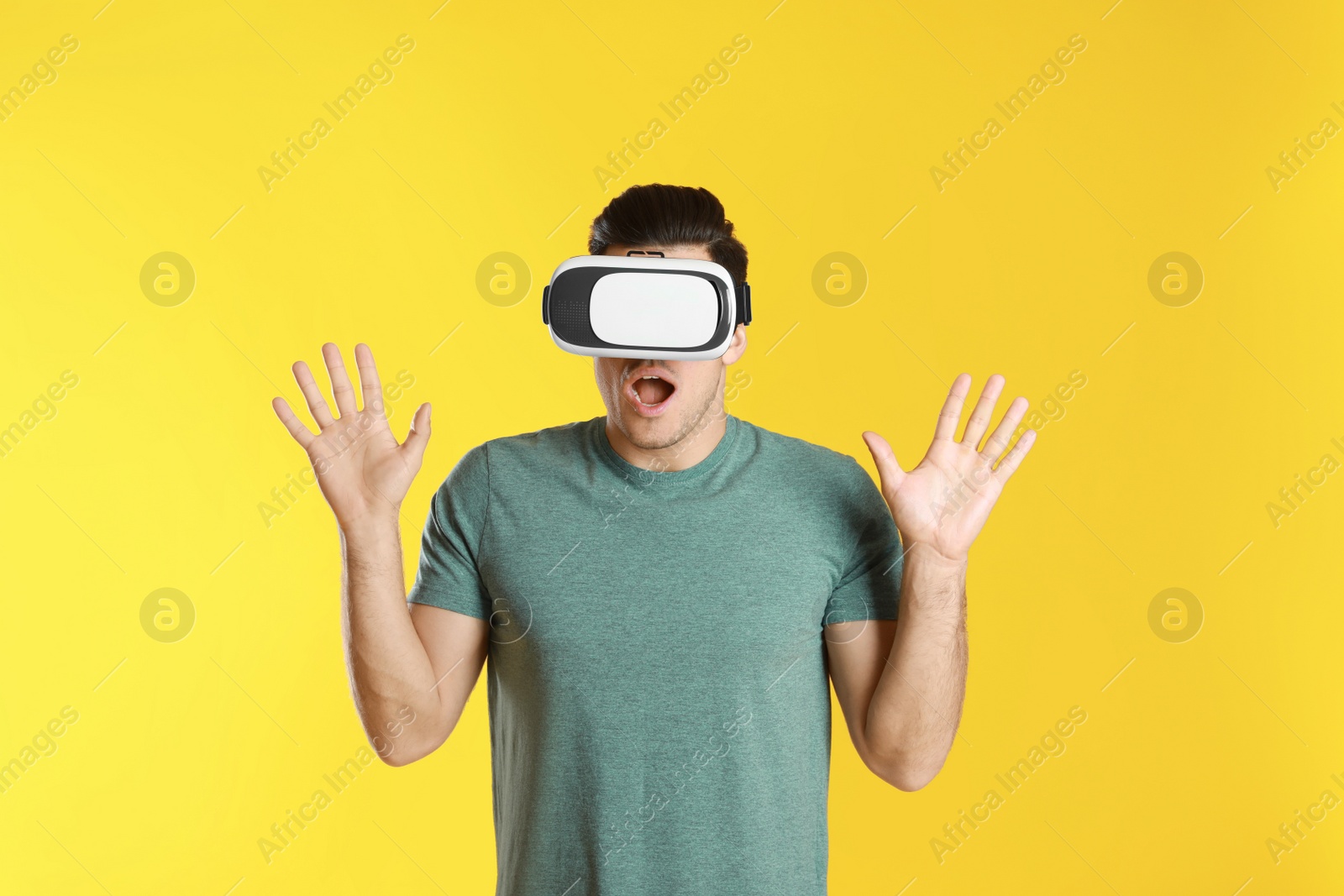 Photo of Man using virtual reality headset on yellow background