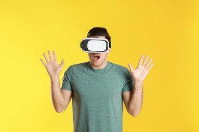 Man using virtual reality headset on yellow background