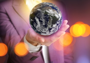Image of World in our hands. Woman holding digital model of Earth, closeup view 