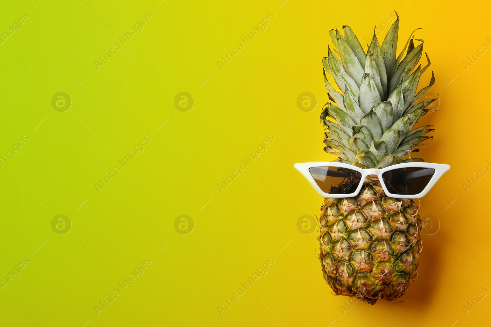 Image of Pineapple with sunglasses and space for text on color background, top view. Summer party 
