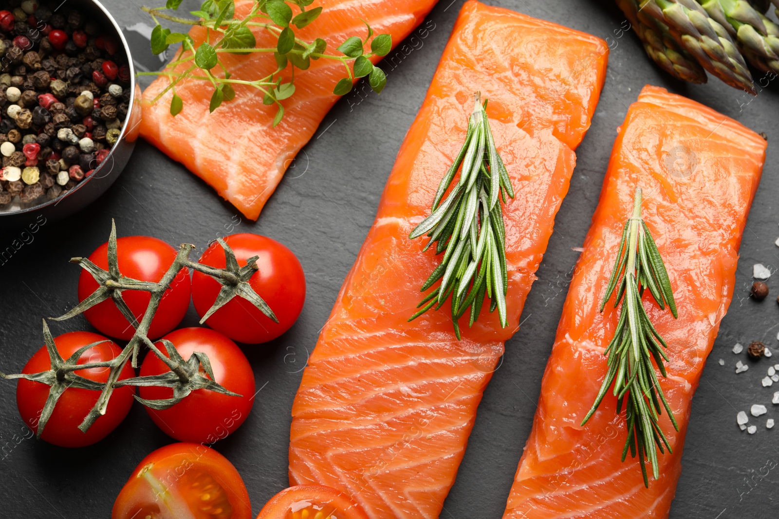 Photo of Fresh raw salmon and ingredients for marinade on black table, flat lay