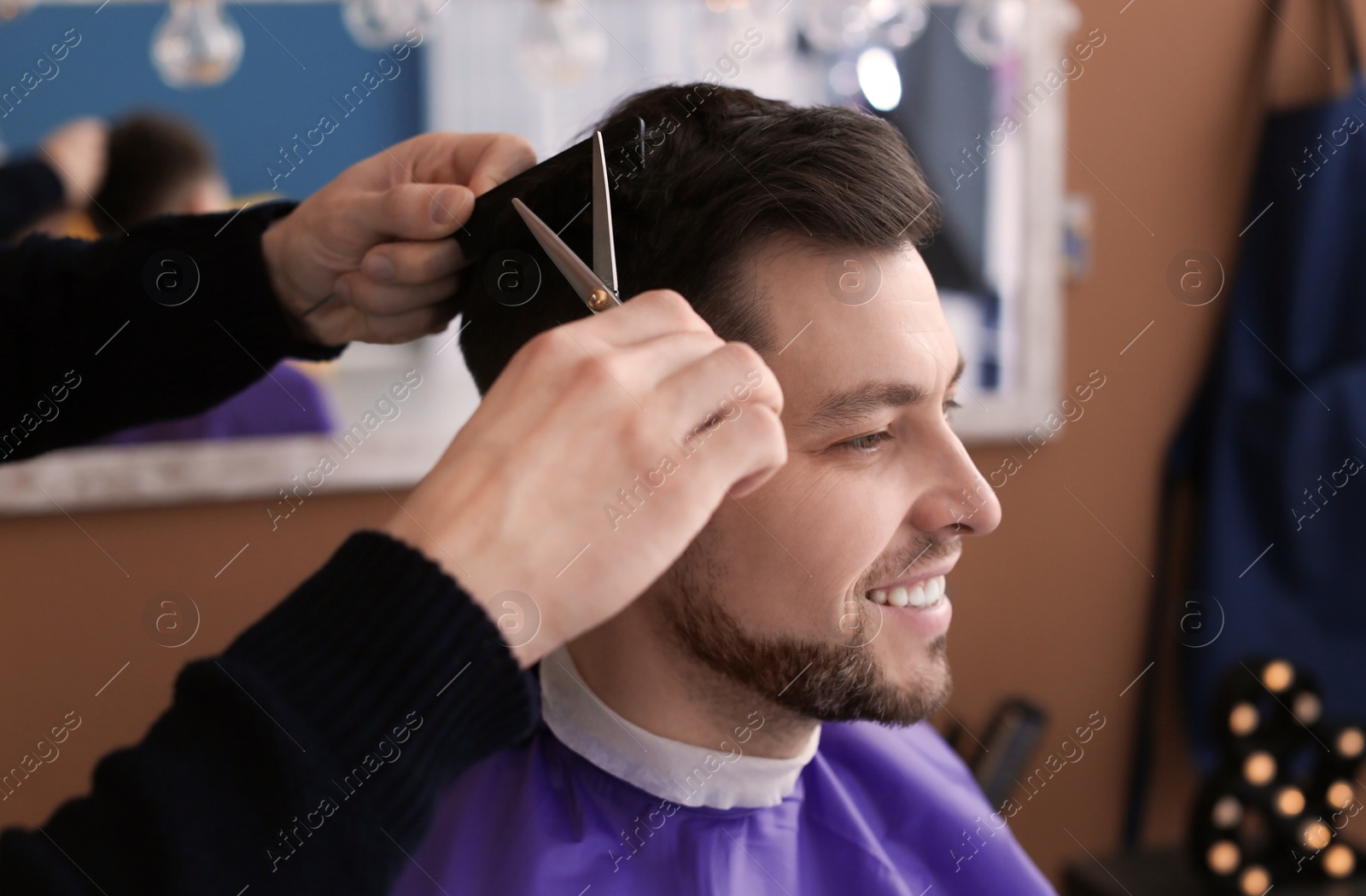 Photo of Professional hairdresser working with client in beauty salon, closeup