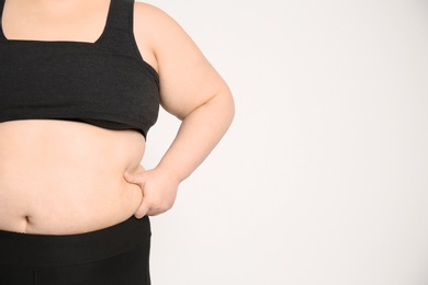 Overweight woman on light background