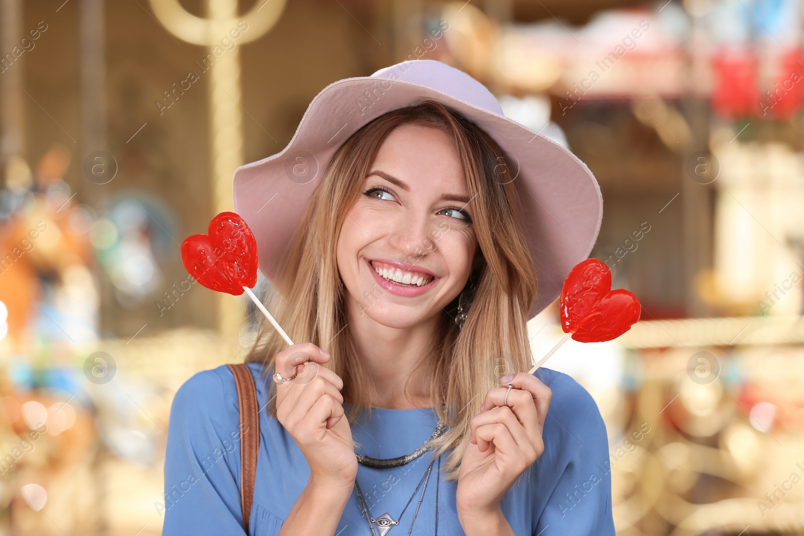 Photo of Beautiful woman with candies having fun at amusement park