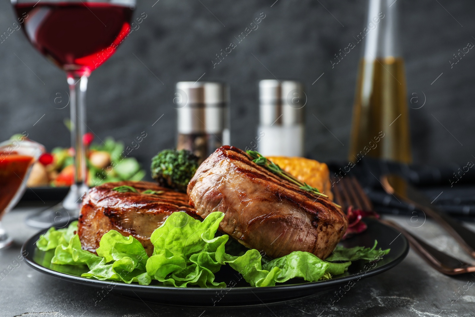 Photo of Delicious beef medallions served on grey table, closeup