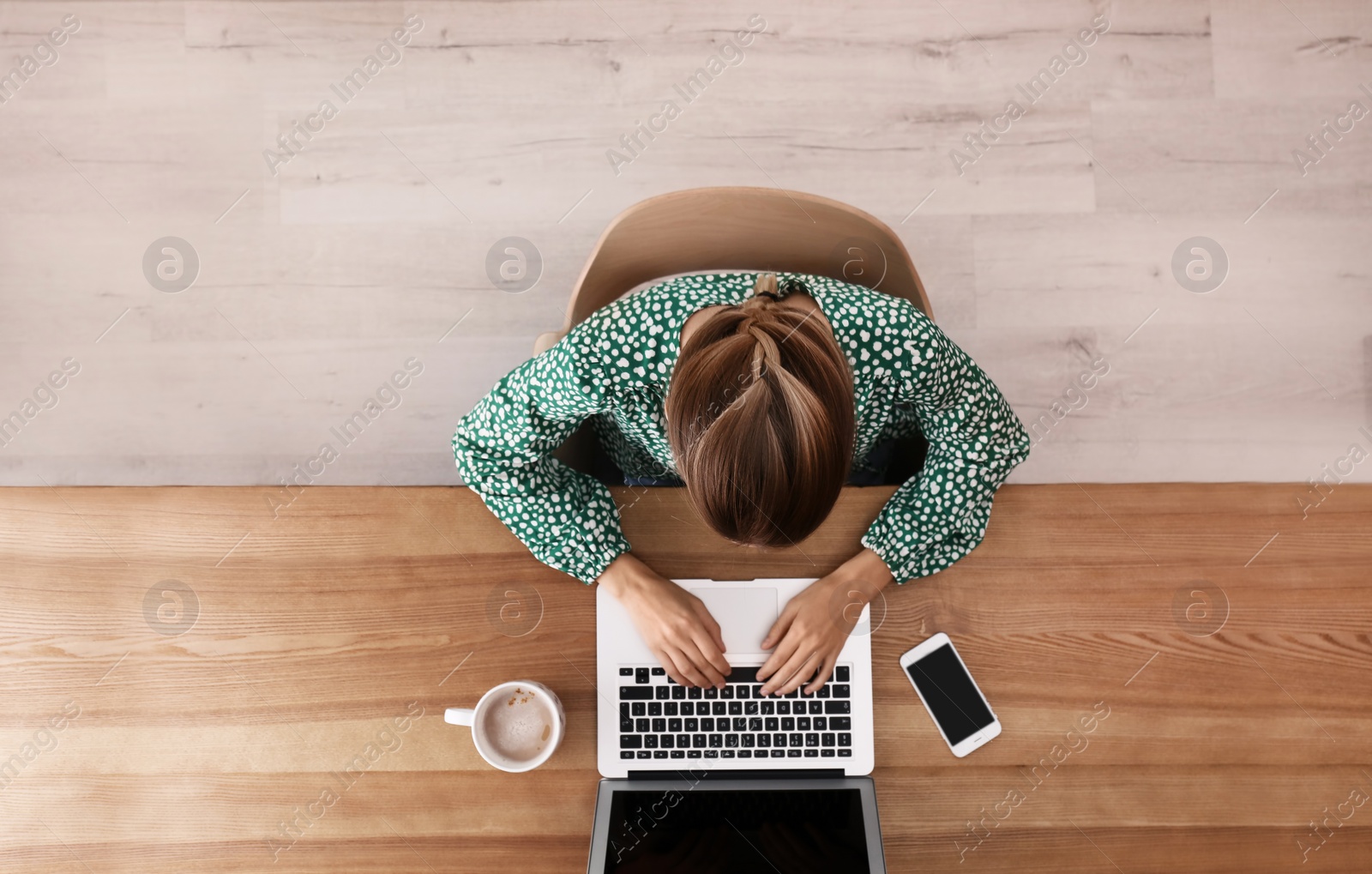 Photo of Woman working with laptop at table indoors, top view