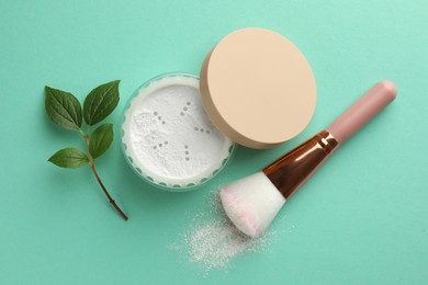 Flat lay composition with rice loose face powder and makeup brush on turquoise background