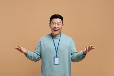 Photo of Excited asian man with vip pass badge on beige background
