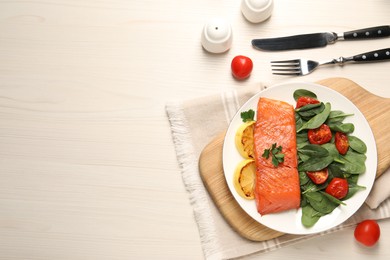 Photo of Tasty grilled salmon with basil, tomatoes and lemon on white wooden table, flat lay. Space for text