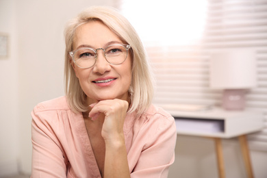 Photo of Beautiful mature woman in glasses at home. Space for text