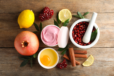 Photo of Flat lay composition with natural homemade mask, pomegranate and ingredients on wooden table