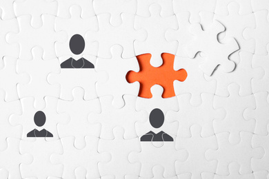 Image of Partnership concept. White puzzle with separated piece on orange background, top view