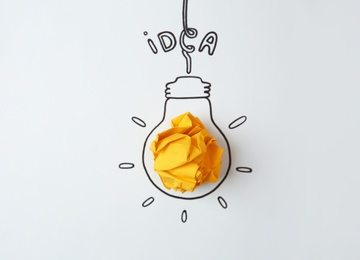 Photo of Drawn lamp bulb, crumpled paper and word IDEA on white background