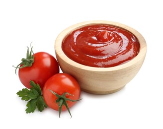 Photo of Tasty ketchup in wooden bowl, fresh tomatoes and parsley isolated on white