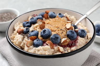 Photo of Tasty oatmeal porridge with toppings served on table, closeup